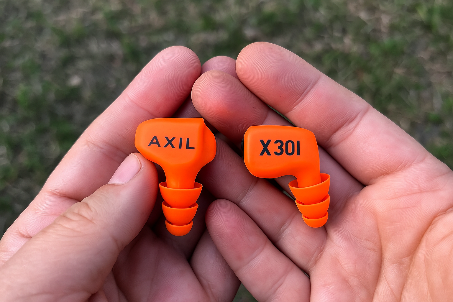 Close-up hands holding AXIL X30I earplugs