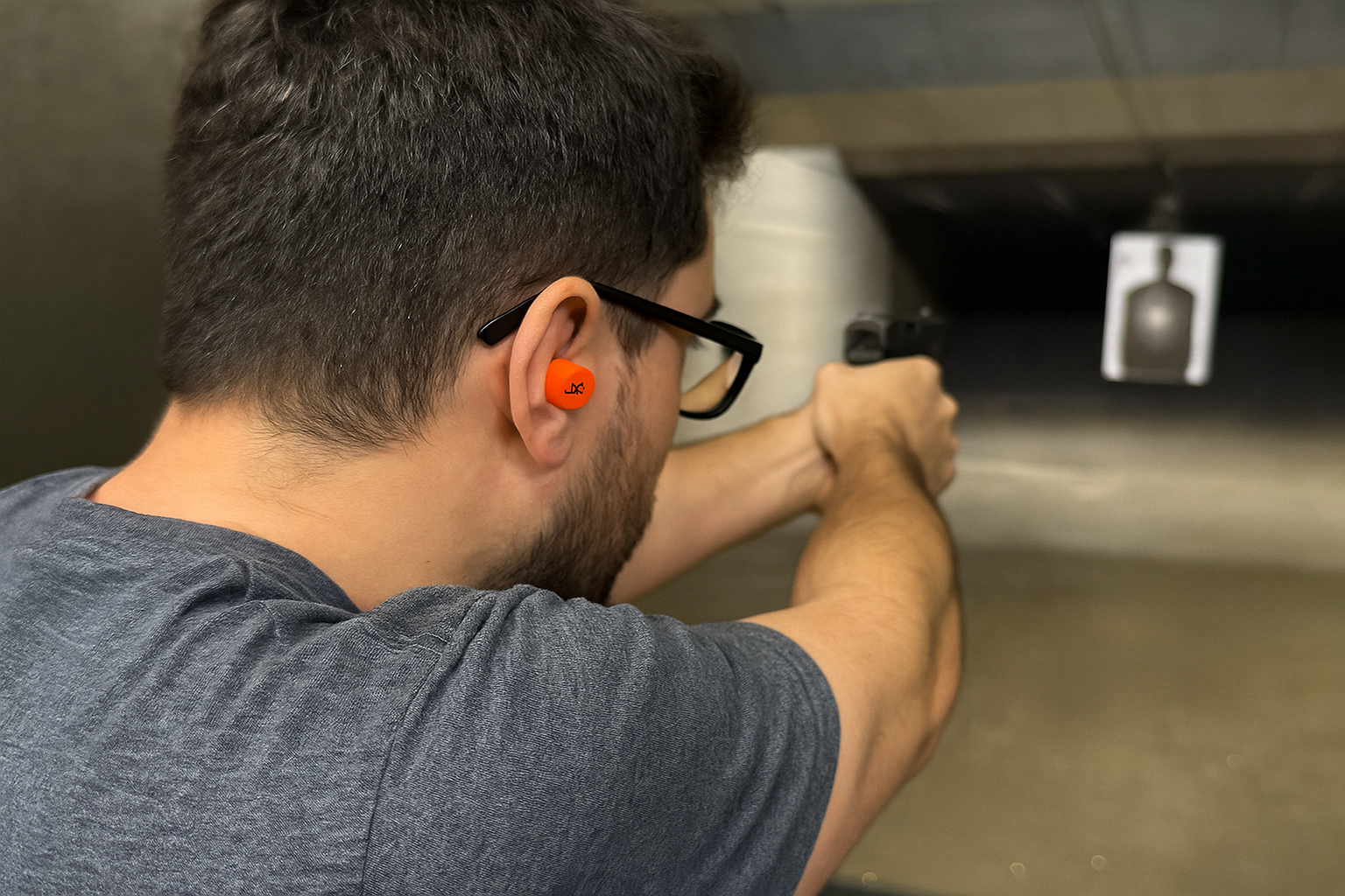 Person wearing earplugs at shooting range